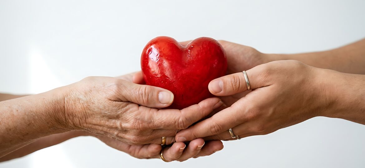 elderly-young-hands-holding-red-heart-together